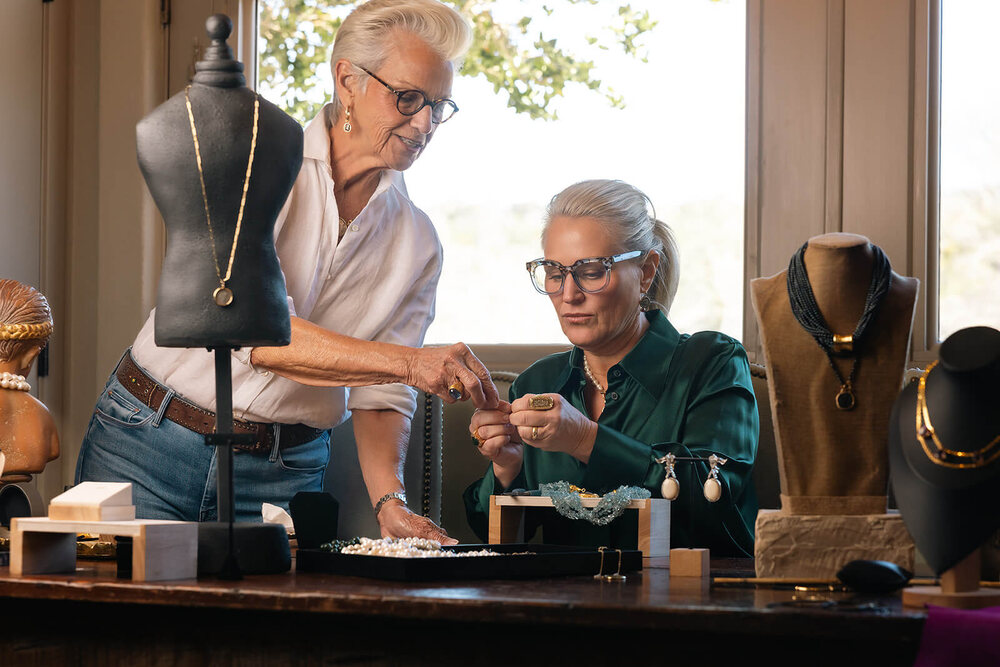 Two jewelry makers assembling a piece together in their studio