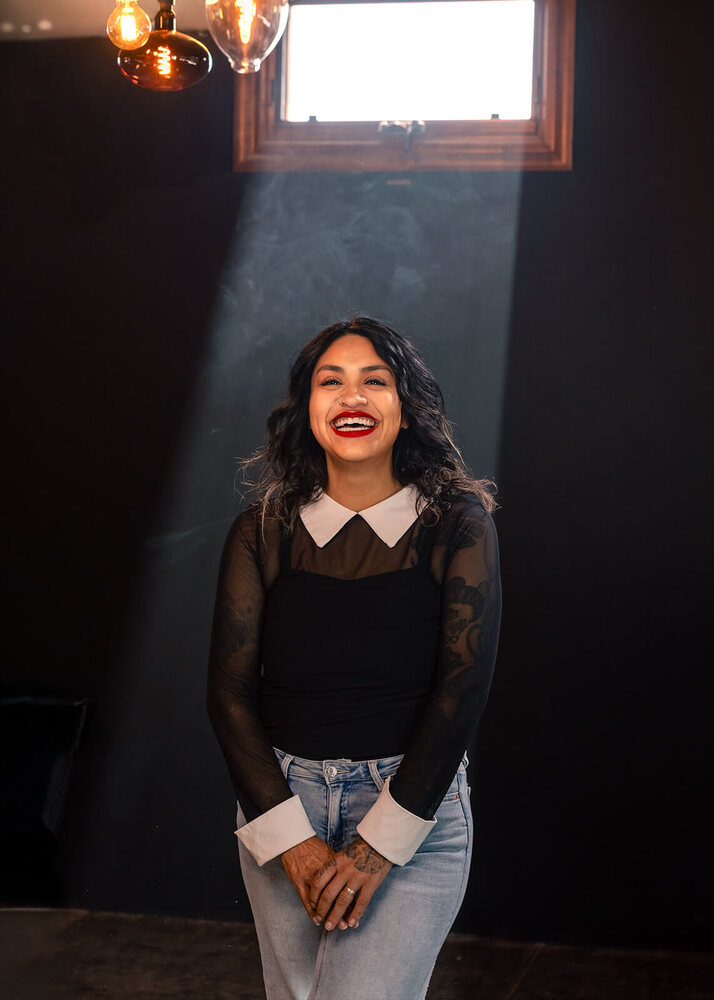 Editorial portrait of a business owner lit against a dark background