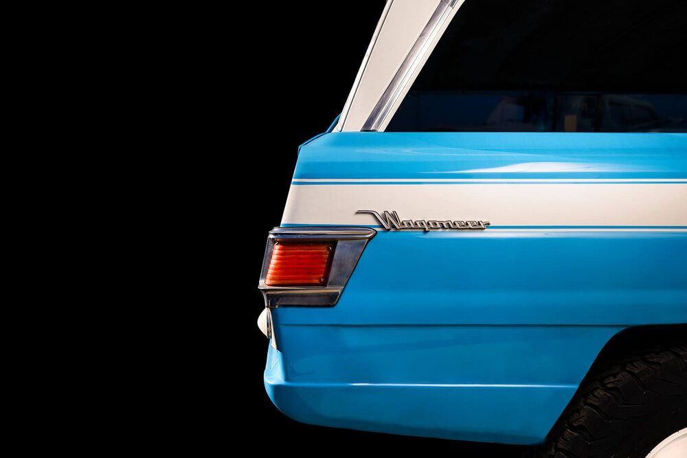 Restored blue Wagoneer photographed against black for a product campaign
