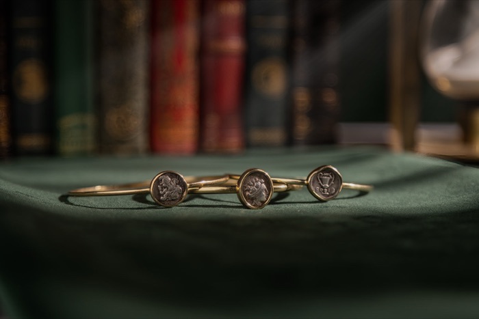 Ancient coin bracelets photographed on green velvet