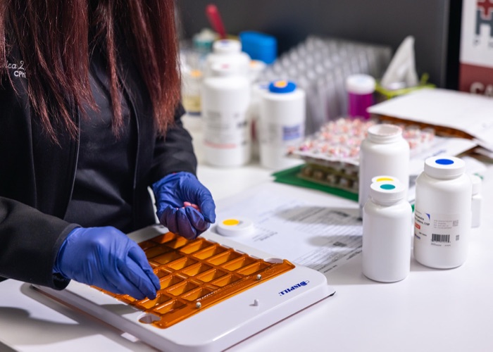 Pharmacy technician assembling medication care packs