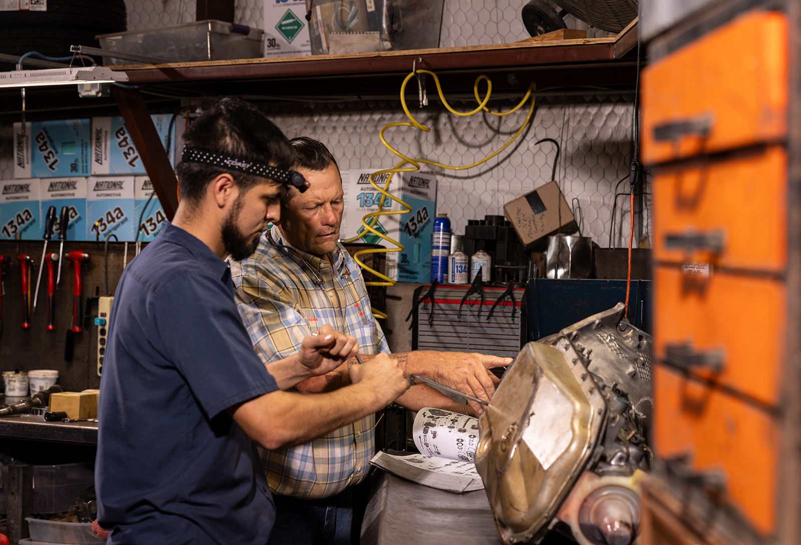 Two technicians working together in a Hill Country automotive shop, photographed on location