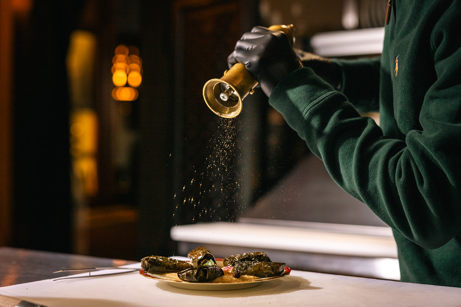 Chef plating a dish under warm light, photographed for a Texas Hill Country restaurant brand