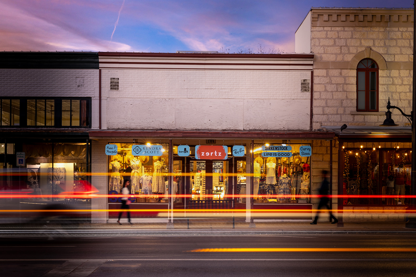 Zertz Boutique storefront at dusk with light trails, photographed for retail brand marketing