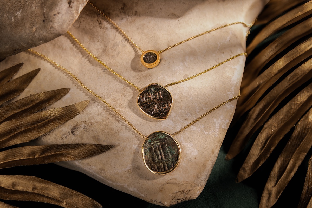 Ancient coin jewelry photographed on a textured natural surface